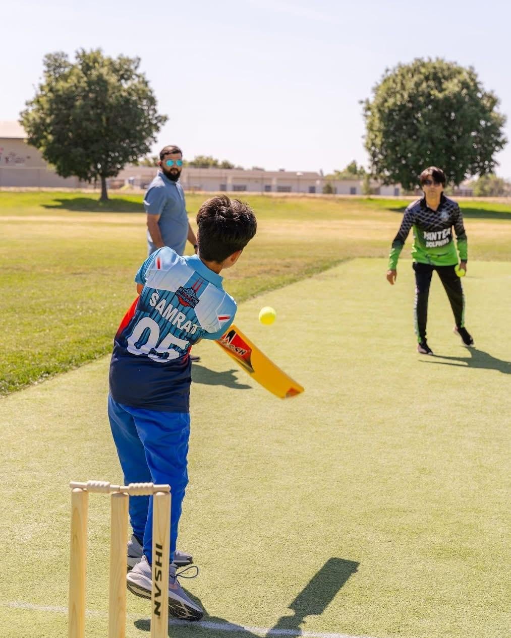 Coach demonstrating batting stance to a student